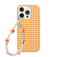 Clear phone case featuring an orange gingham pattern with a matching clear and orange floral beaded phone charm strap.