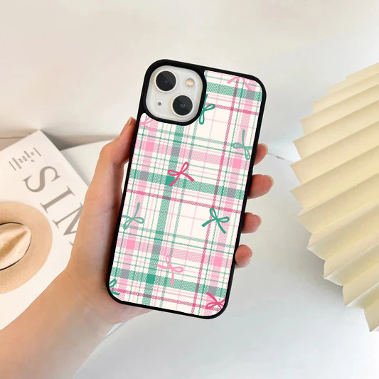 Phone case featuring a pastel pink, teal, and white plaid pattern with scattered small pink and teal bows.
