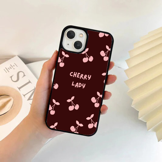 Dark burgundy phone case with a pattern of pink cherries and the words CHERRY LADY printed in the center.