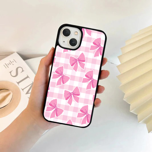 Phone case with a pink and white gingham checkered background, decorated with large pink ribbon bows.