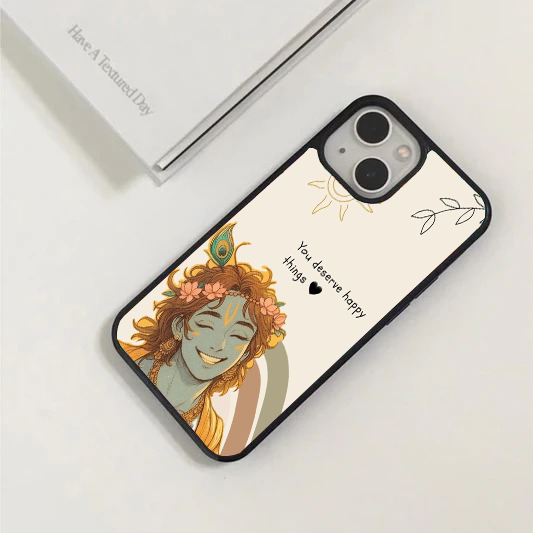 Beige phone case with a cute, colorful illustration of a smiling Lord Krishna, a line-art sun, and the text "You deserve happy things".