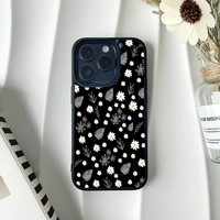 Black phone case with a pattern of small white daisies and white line-art leaves.