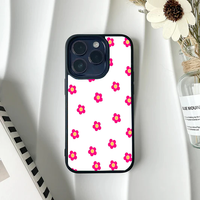 White phone case with a sparse, minimalist pattern of small bright pink flowers with yellow centers.