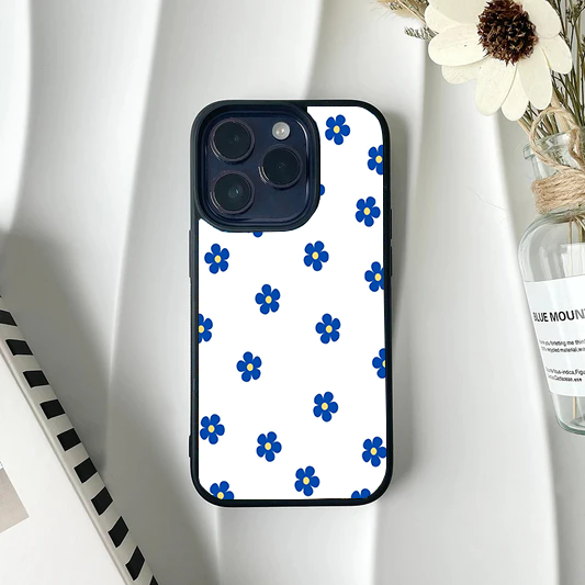 White phone case featuring a repeating minimalist pattern of small royal blue flowers with yellow centers.