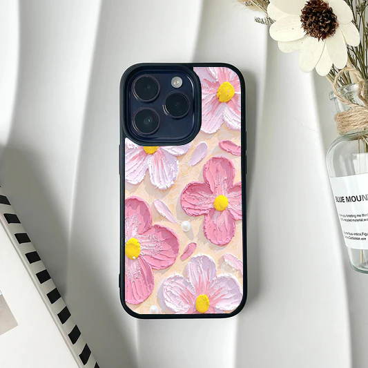 Phone case showing a faux-textured impasto painting of pink and white daisies with falling petals on a pale peach background.
