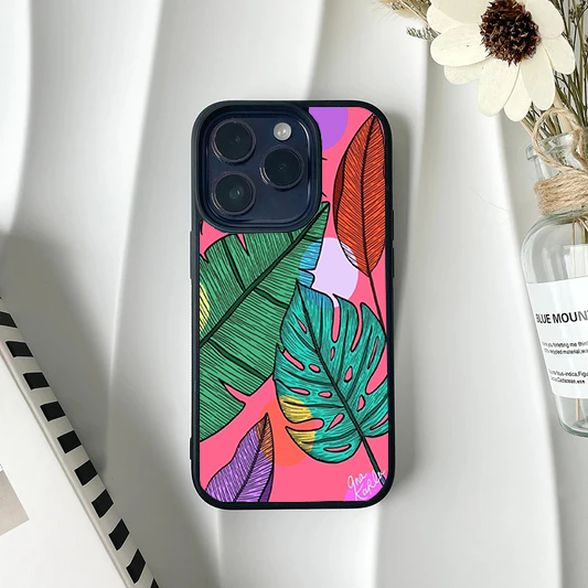 Phone case featuring detailed, hand-sketched colorful tropical leaves over a vibrant pink abstract background.