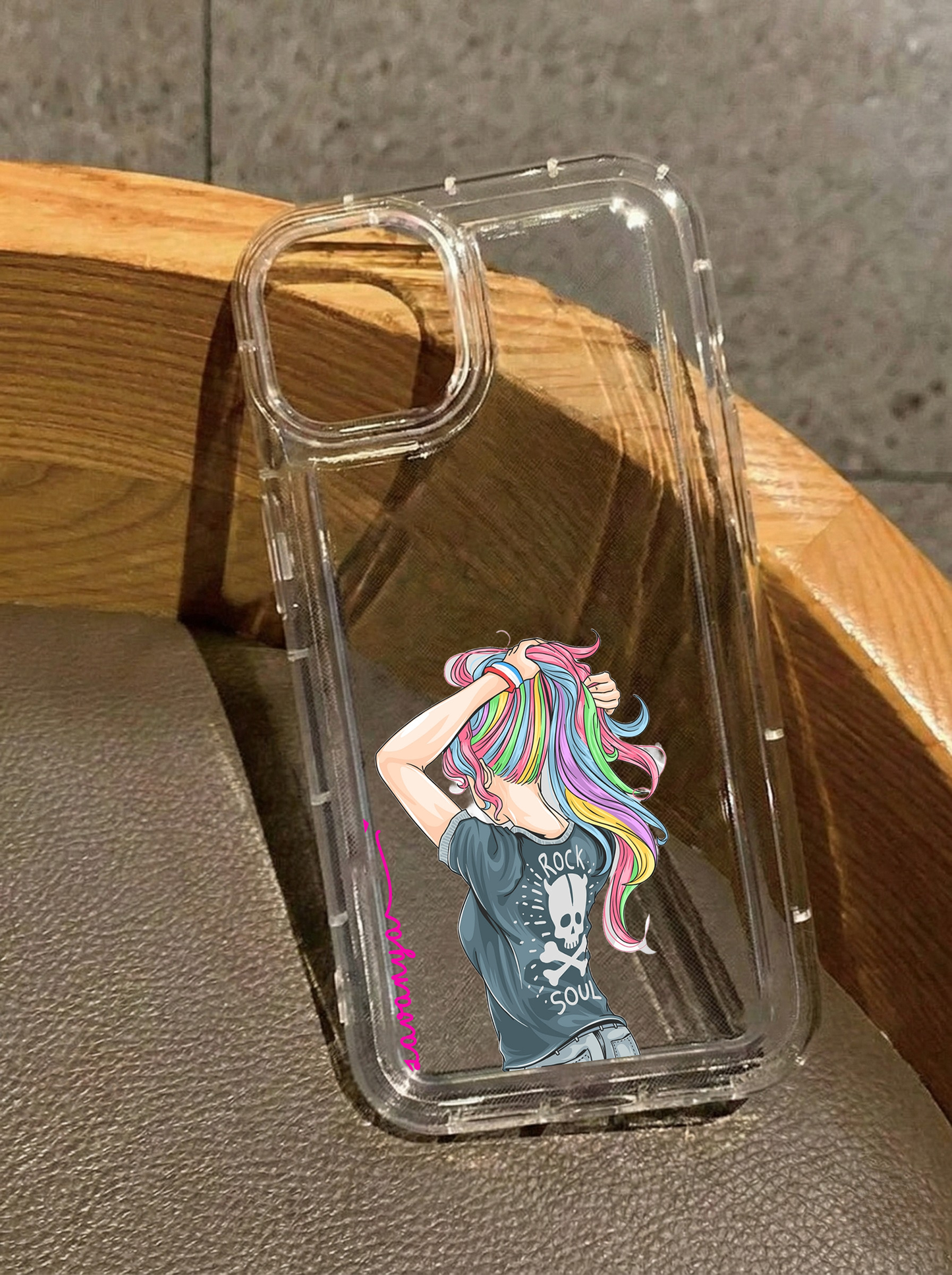 Clear iPhone 16 case displaying an illustration of a girl with rainbow hair wearing a Rock Soul skull t-shirt, customized with the name Lavanya in vertical pink text.