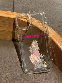 Clear iPhone 16 case featuring an illustration of a girl sitting down wearing a floral crown and holding a phone, customized with the name Komalarya in pink script.