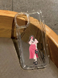 Clear iPhone 16 case featuring a trendy illustration of a girl in a pink midi skirt and top taking a mirror selfie holding a black bag, customized with the name Sapna Barah in vertical black text.