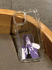 Clear iPhone 16 case with an illustration of a girl with pigtails wearing a purple varsity jacket taking a mirror selfie, featuring the customized name Ipshita in black text.