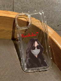 Clear iPhone 16 case showing an illustration of a girl with long brown hair wearing a grey face mask and sunglasses, customized with the name Ruchika in red text.